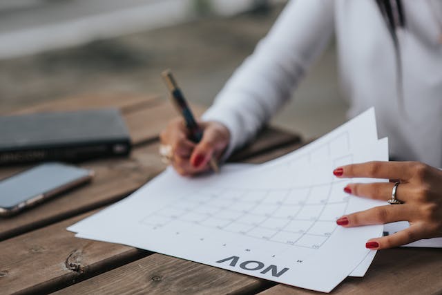 person writing down dates on a calendar